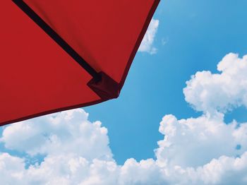 Low angle view of red umbrella against blue sky