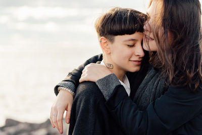 Young couple kissing against sea