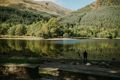 Man standing by lake against mountain