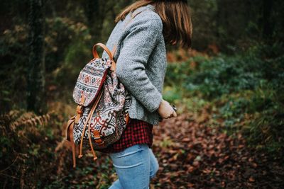 Rear view of woman walking in forest