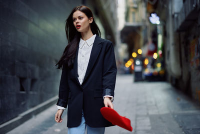 Portrait of young woman standing in city