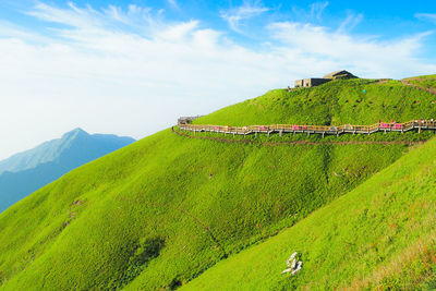 Scenic view of green landscape against cloudy sky