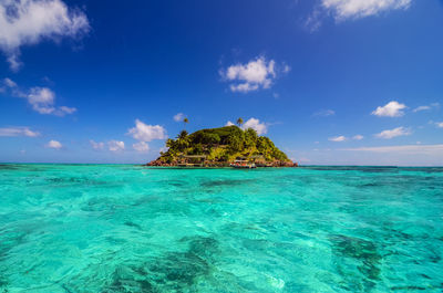 Island amidst turquoise sea against sky