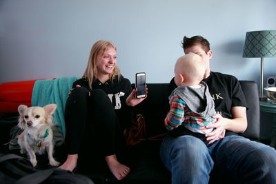 Young woman with dog sitting on sofa