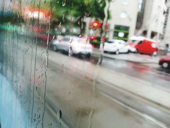 Cars on road seen through wet window