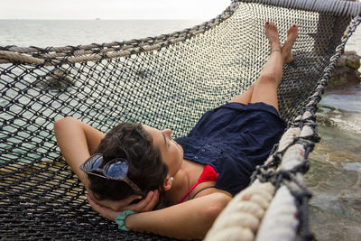 High angle view of woman lying on hammock