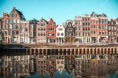 Canal in city against sky