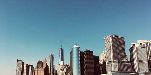 Low angle view of skyscrapers against blue sky