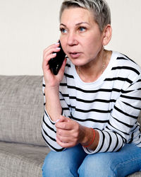 Young man using mobile phone while sitting at home