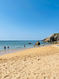 Scenic view of beach against clear blue sky