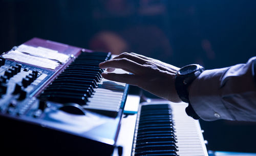 Cropped hand of man playing piano