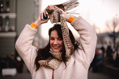 Portrait of smiling young woman holding camera