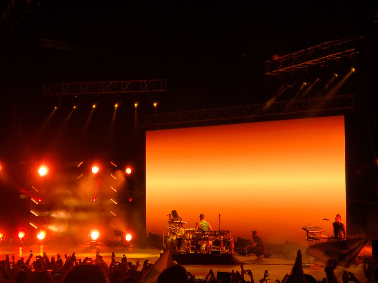 PEOPLE AT ILLUMINATED CITY AGAINST SKY