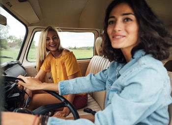 Portrait of a smiling young woman sitting in car