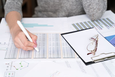 Midsection of woman reading book on table