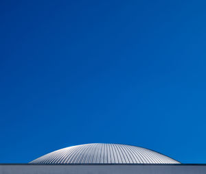 Low angle view of modern building against clear blue sky