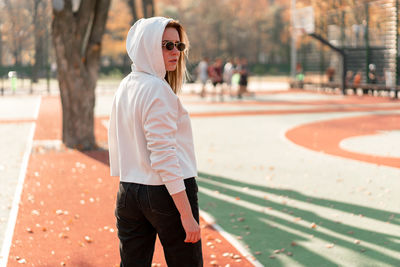 Young woman standing at playing field during autumn