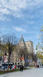 Group of people on street against buildings in city