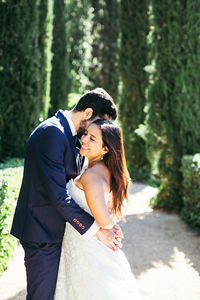 Newlywed couple romancing while standing in park