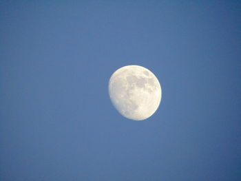 Low angle view of moon against clear blue sky