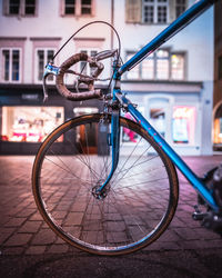 Close-up of bicycle parked on street against building