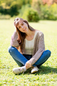 Portrait of young woman sitting on grass