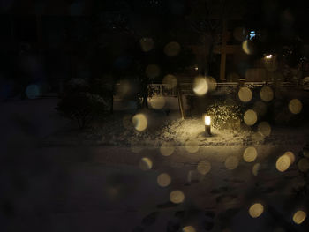 Illuminated lights on wet street at night