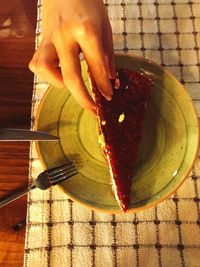 Close-up of woman hand holding ice cream in plate