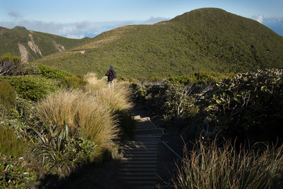 People riding bicycle on footpath by mountains