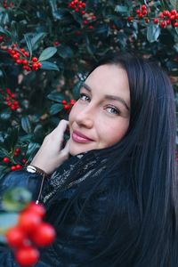 Portrait of smiling beautiful young woman by plants