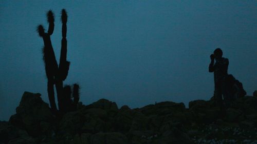 Low angle view of silhouette rocks against clear sky