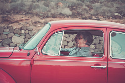 Cheerful senior couple traveling in car