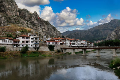 Scenic view of river by mountains against sky