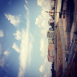 Buildings in city against cloudy sky