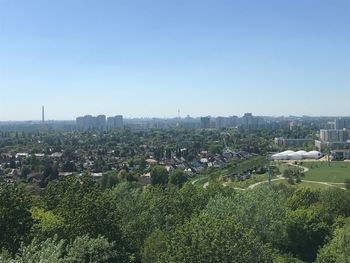 High angle view of trees and buildings against clear sky