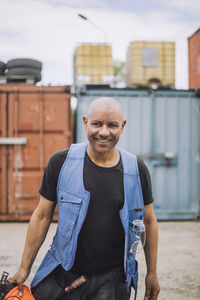 Happy bald construction worker walking at site