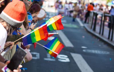 Group of people holding rainbow flags on street