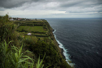 High angle view of calm beach against cloudy sky