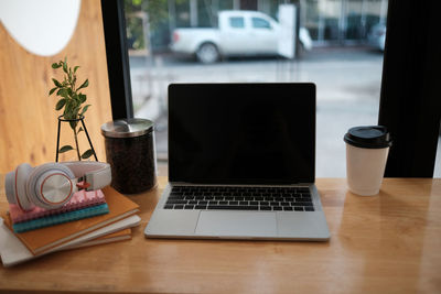 Coffee cup on laptop on table