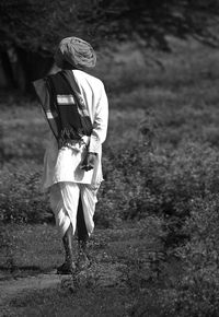 Rear view of woman walking on field