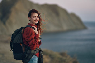 Portrait of smiling young woman standing in sea