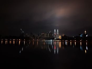 Illuminated cityscape against sky at night