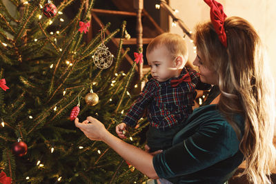 Rear view of woman holding christmas tree