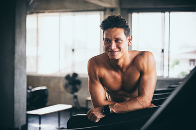 Portrait of shirtless man looking at camera