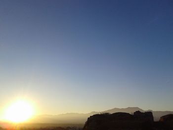 Scenic view of mountains against clear sky during sunset