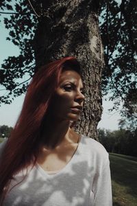 Young woman with tree trunk