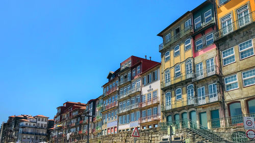Low angle view of buildings against clear blue sky