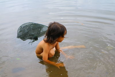 High angle view of shirtless boy in lake