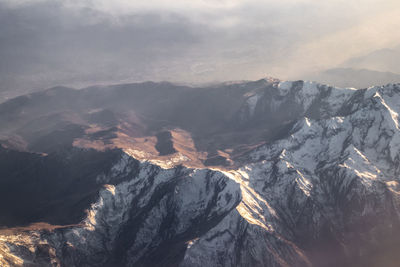 Aerial view of snowcapped mountains against sky