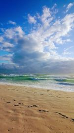 Scenic view of beach against blue sky